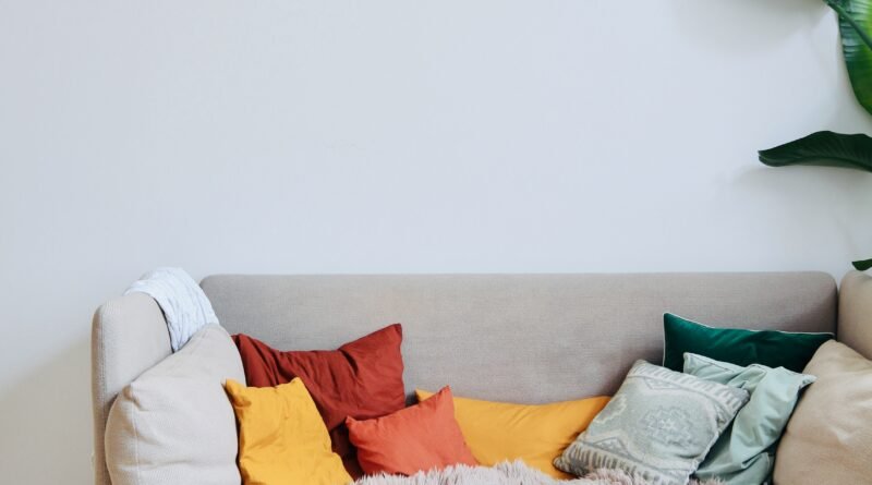 Cozy living room with a warm neutral sofa, wooden floor and colourful autumn cushions