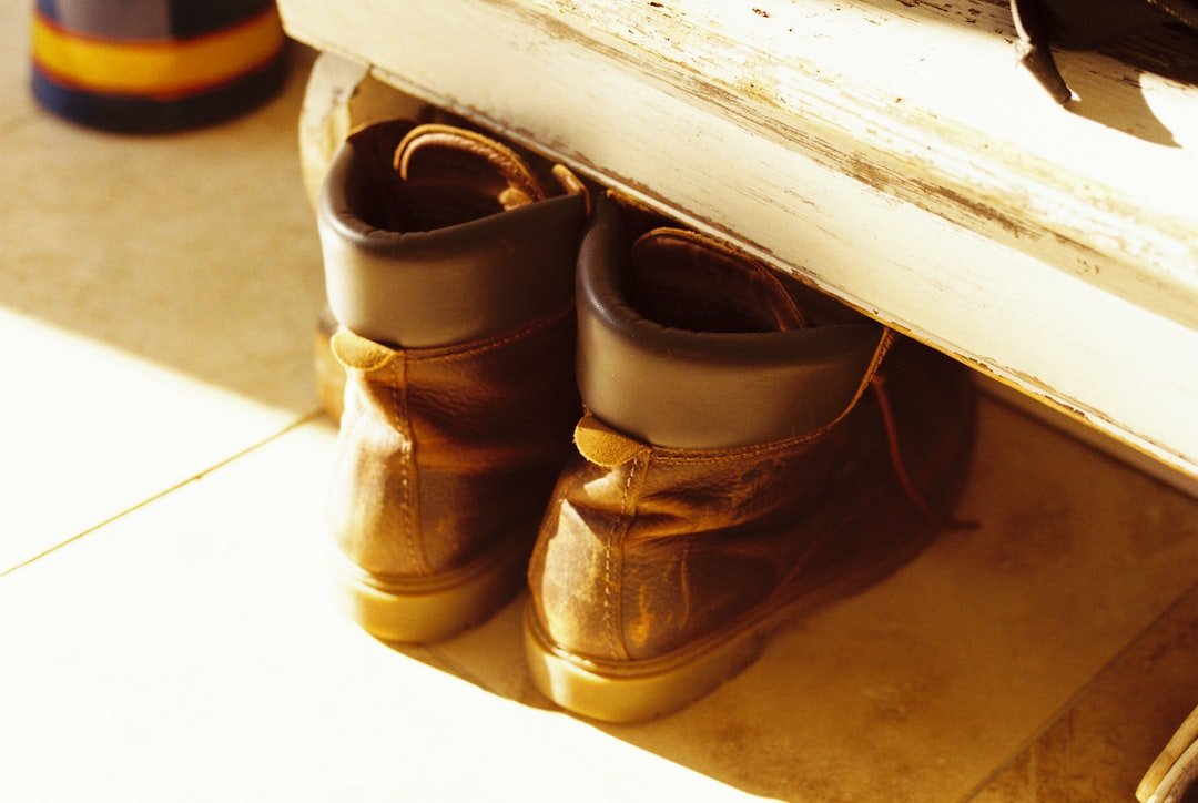 Leather boots tucked under a painted entryway bench as simple shoe storage