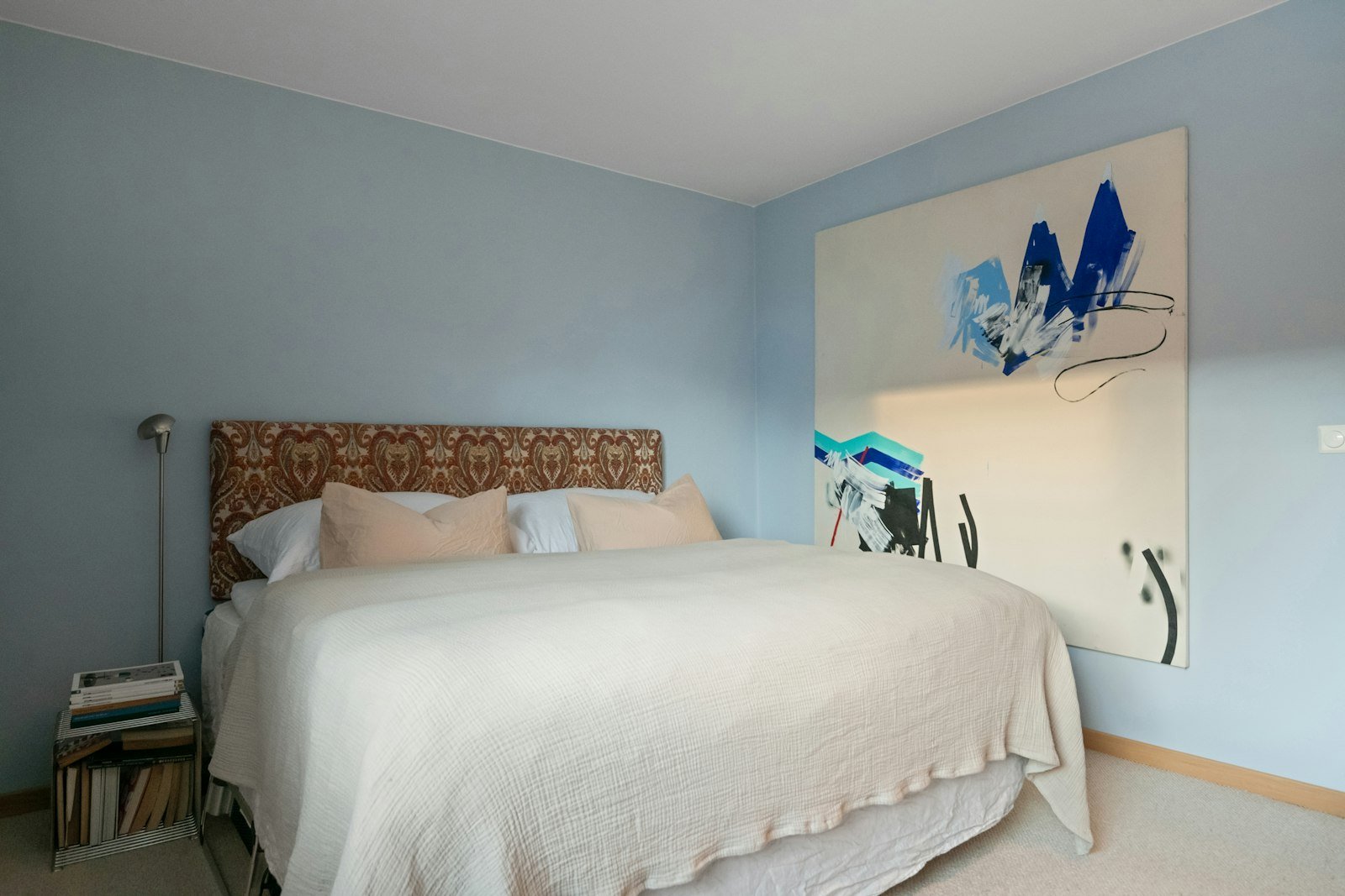 Coastal blue bedroom idea with light blue walls and a white bed