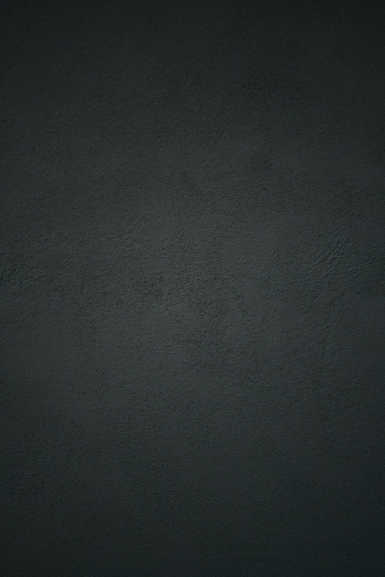Close-up of a dark charcoal plaster wall with subtle uneven texture