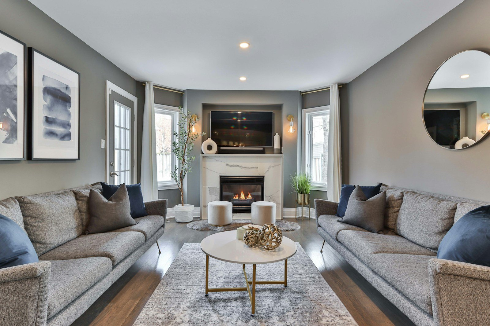 Deeper greige living room with a gray sofa and white fireplace, a neutral living room idea for bright rooms