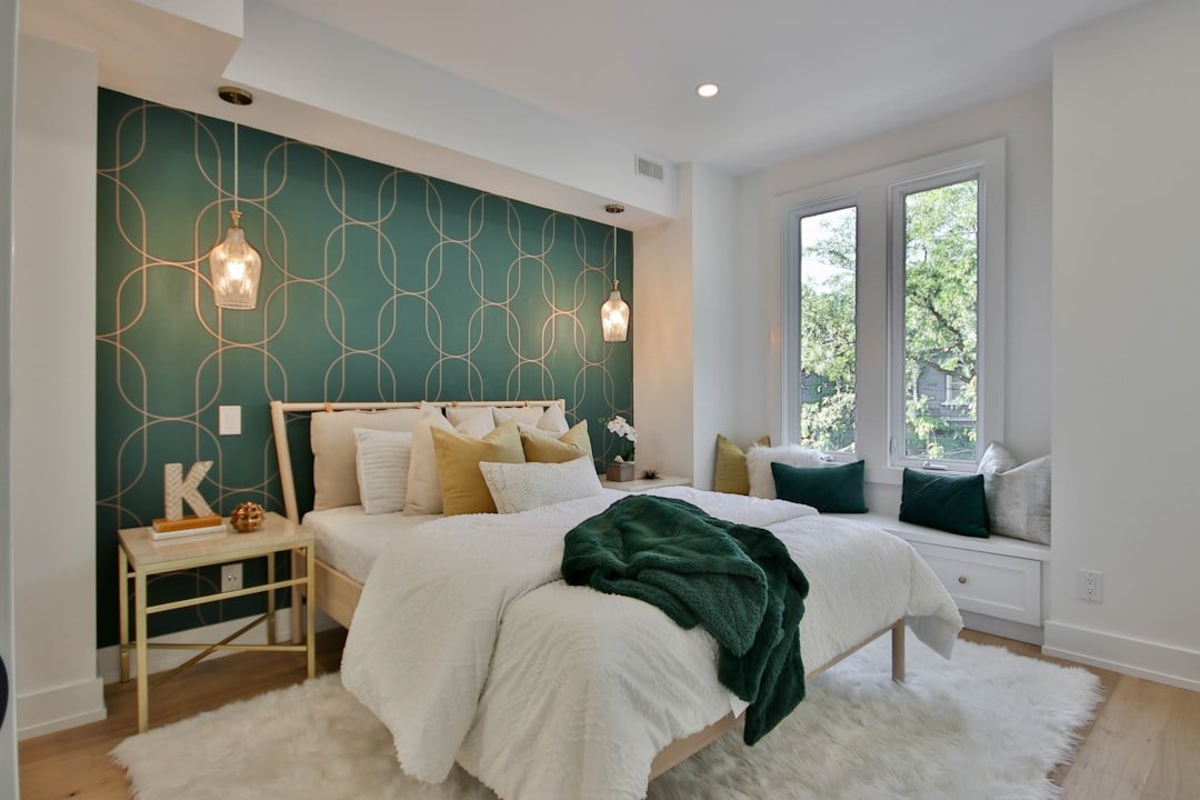 Green accent wall bedroom styled with white bedding and wood