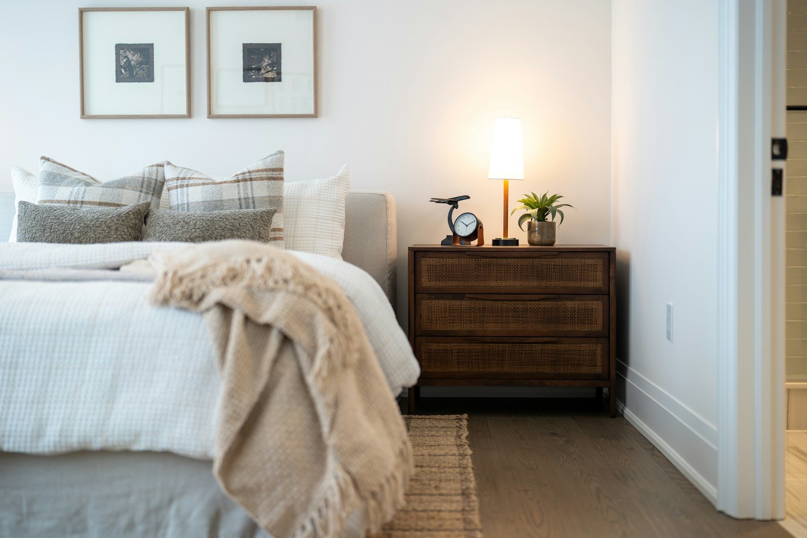 Layered linen bedding and warm bedside lamplight keeping a dark bedroom cozy