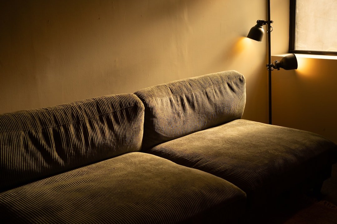 Living room sofa illuminated by a pair of warm wall sconces