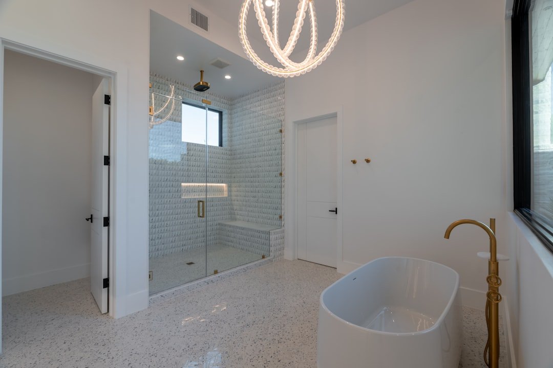 Modern bathroom shower ideas with a frameless glass enclosure and freestanding tub