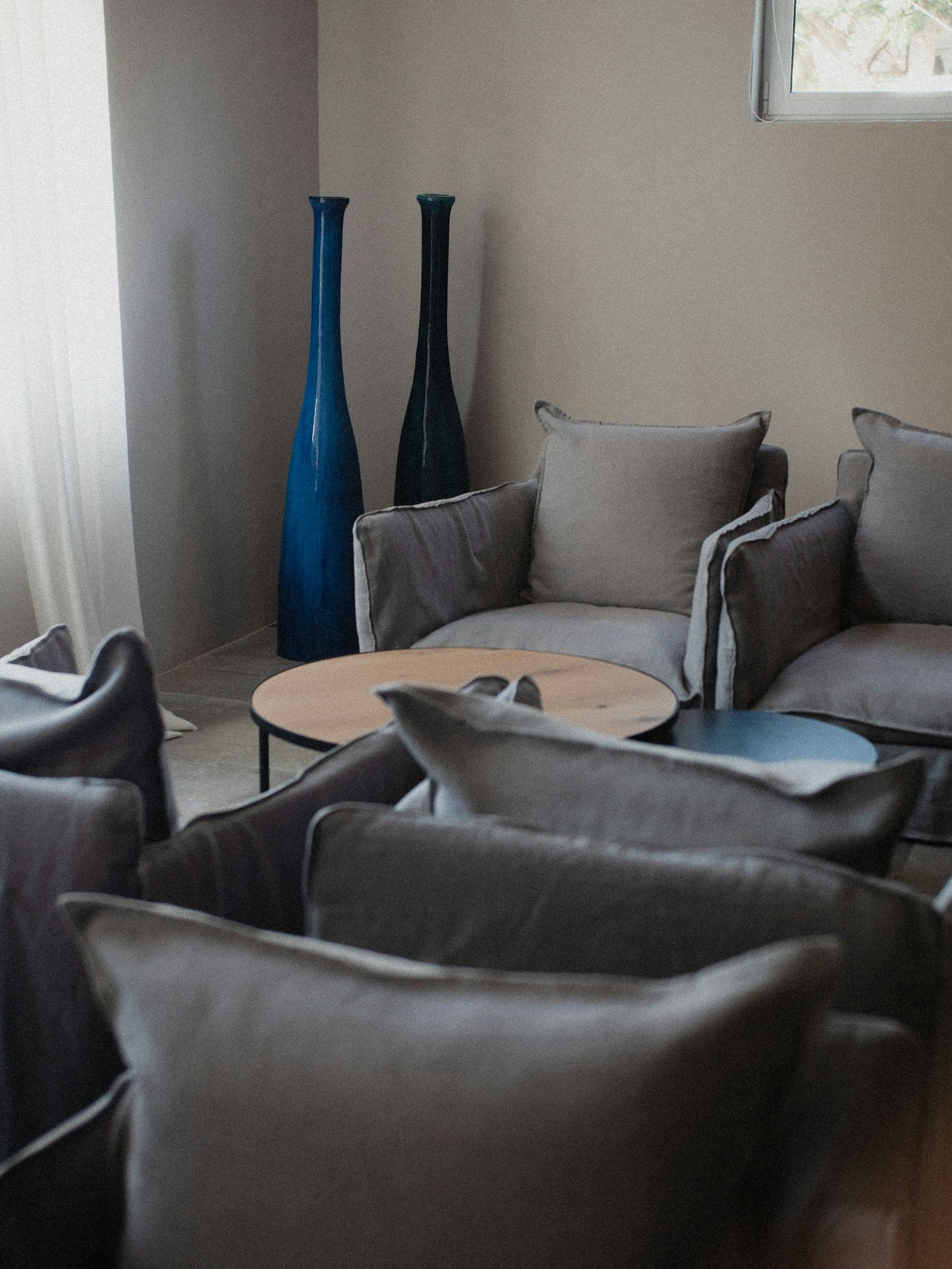 Warm neutral living room with a blue accent, showing navy paired with beige and cream