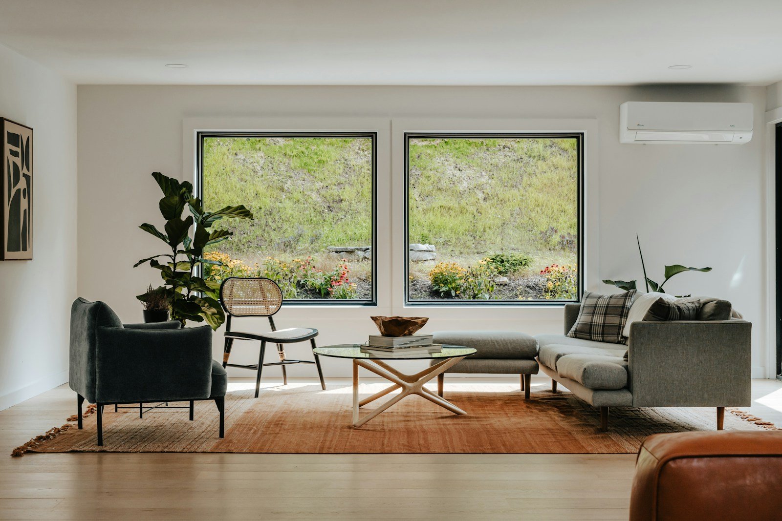 Neutral living room with dark framed windows adding contrast to a soft neutral color scheme