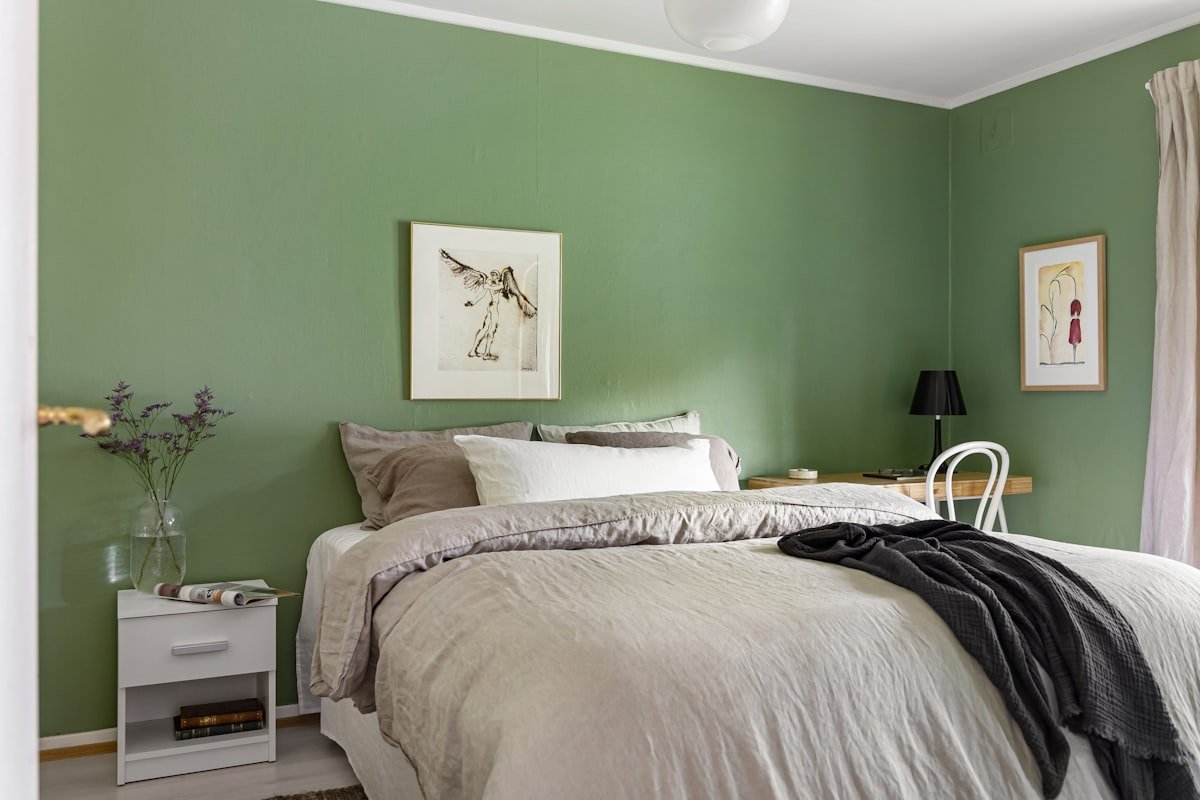 Bedroom with olive green walls and crisp white linen bedding