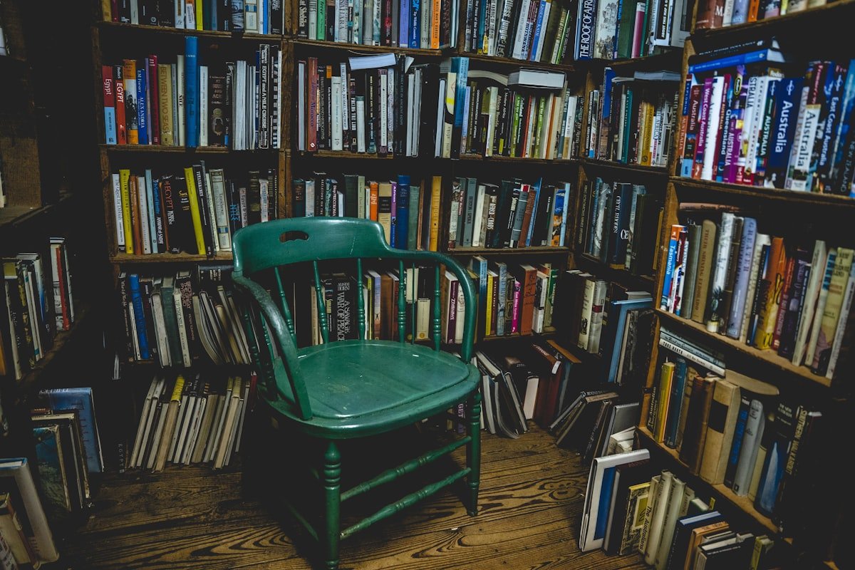 Olive green chair next to wooden bookshelves showing olive green furniture and textiles