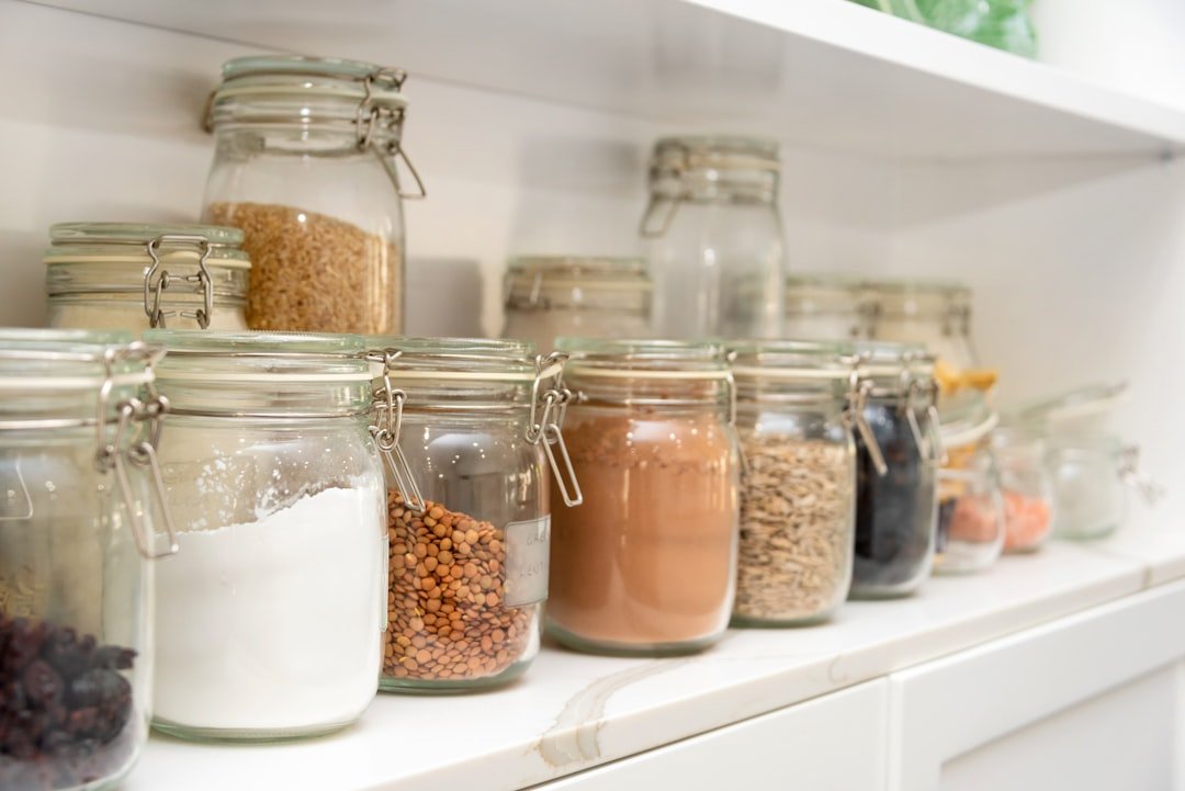 Pantry organization with matching airtight containers and jars lined up on white shelves