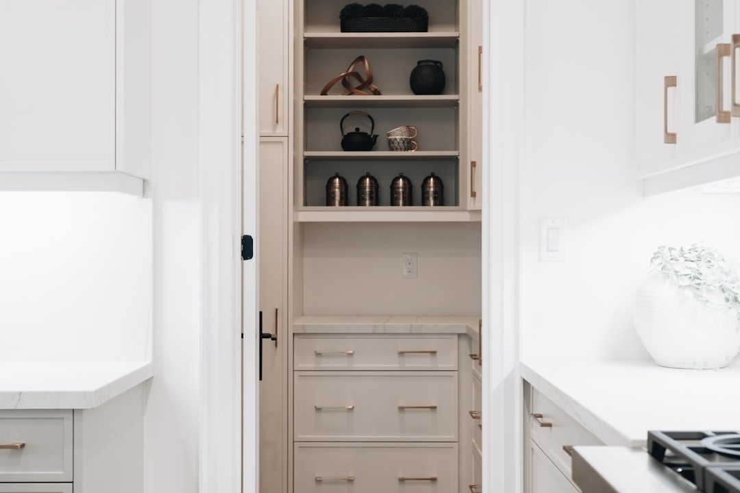 Pantry organization ideas using pull out drawers and open shelving in a modern pantry