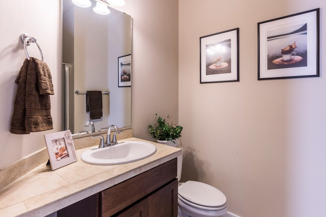Small modern bathroom ideas with a compact vanity, round mirror and pale walls