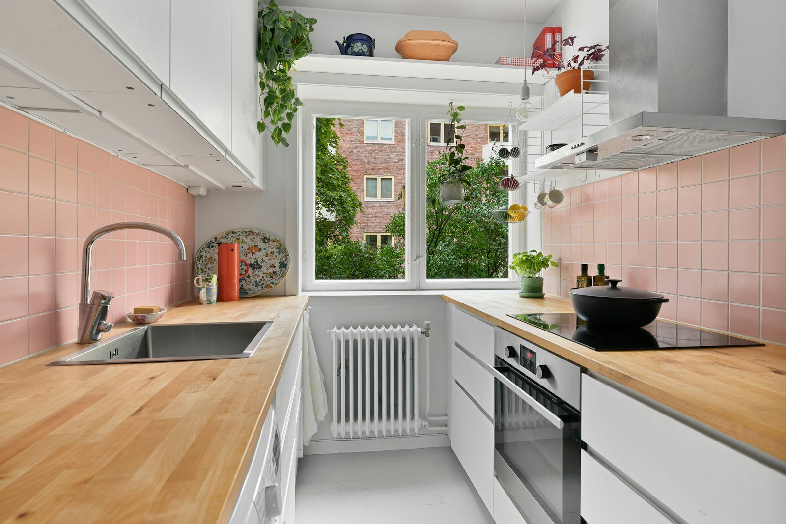 Small rental apartment kitchen with a wood counter and white cabinets