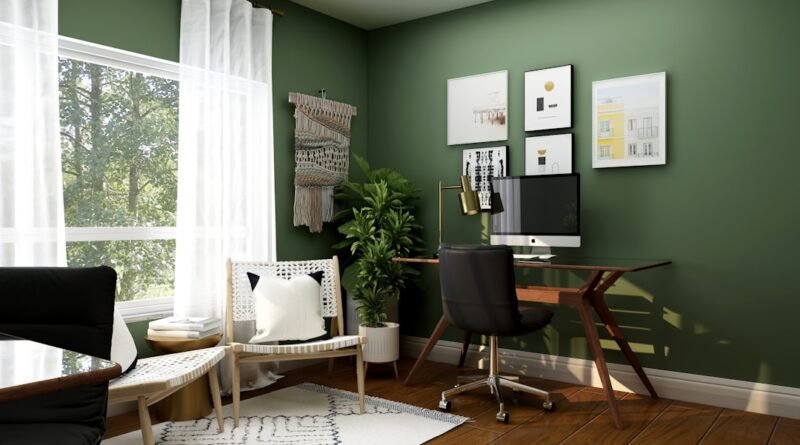 Home office with a wood desk, black chair, green walls, and warm natural decor
