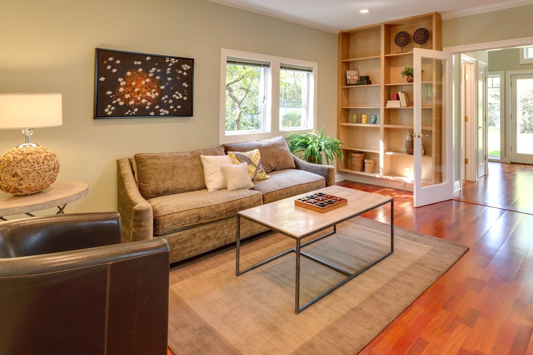 Warm brown living room with wood furniture, shelving, and neutral upholstery