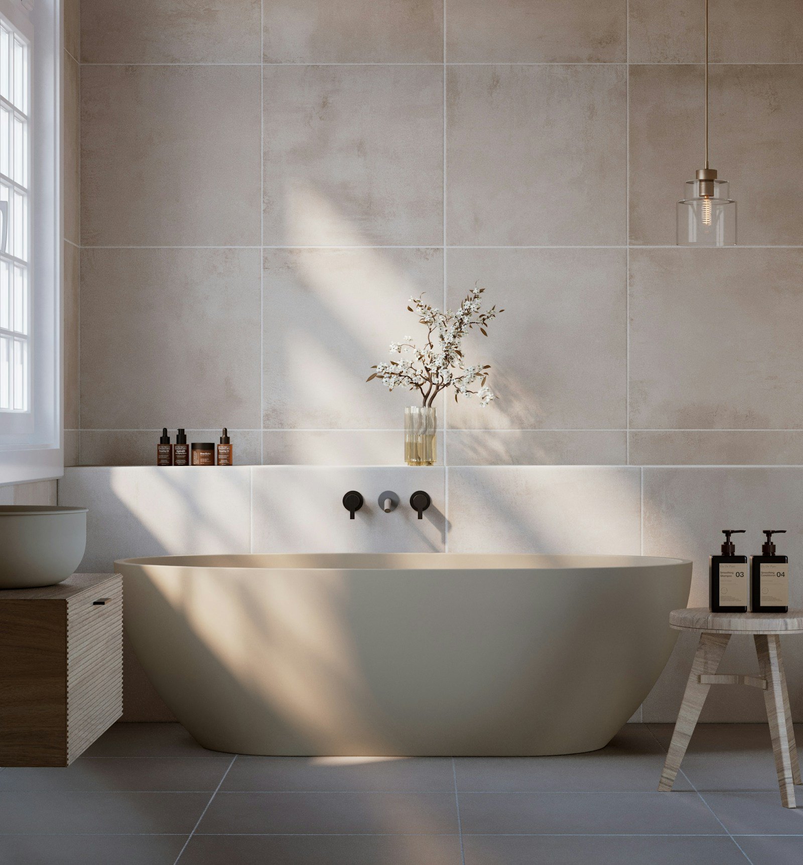 Beige bathroom idea with warm neutral stone tile, freestanding tub and natural light