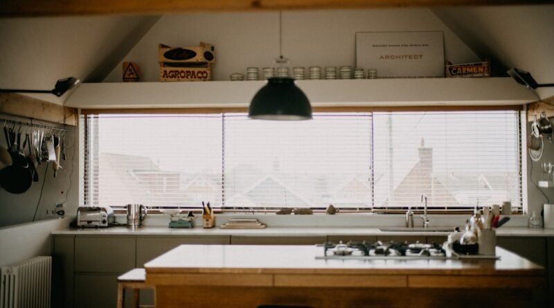Bright white kitchen with a wood island and large window, an example of warm white kitchen ideas