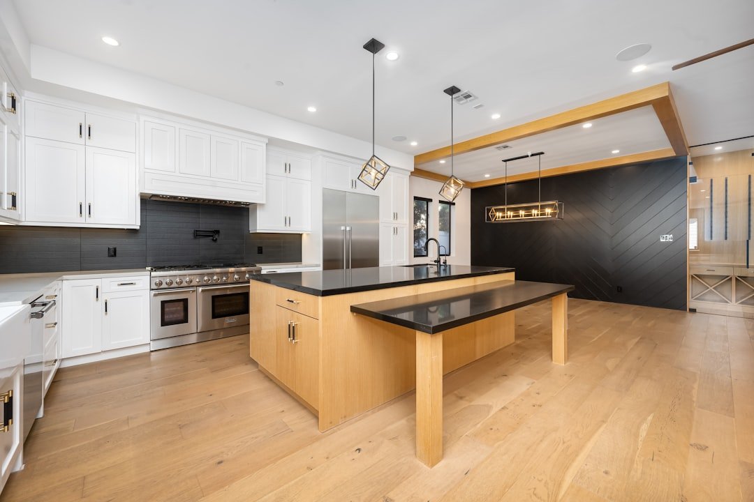 White kitchen with a large wood island and oak flooring, adding warmth to a white kitchen