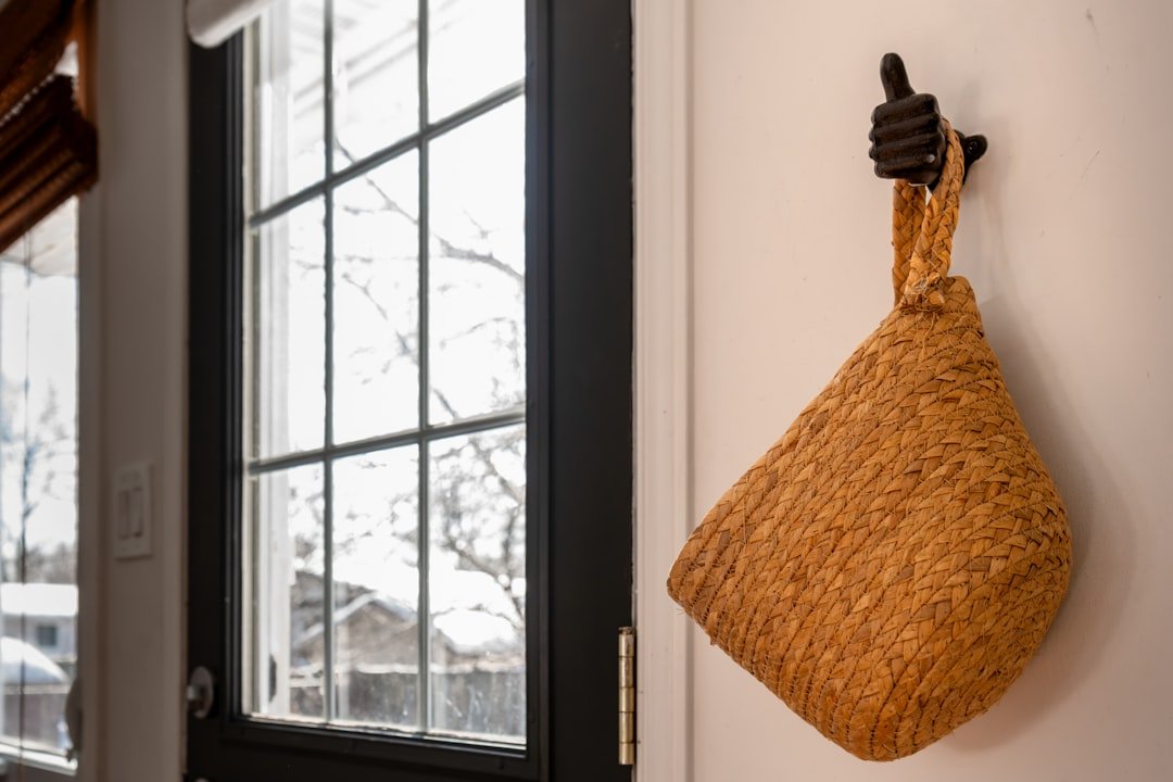 Woven basket hung on an entryway wall for storing small everyday items