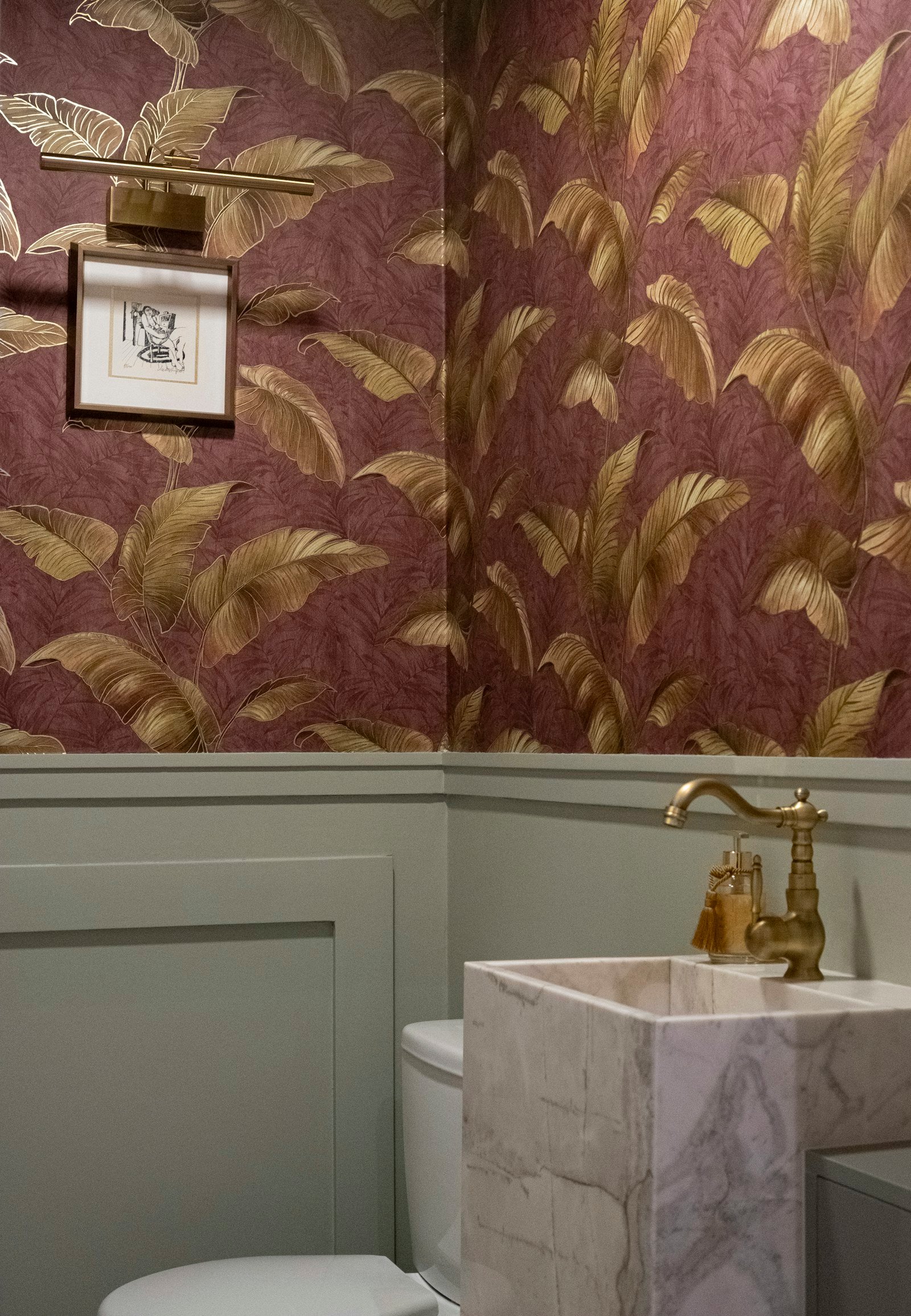 Powder room with botanical floral wallpaper, marble sink and warm brass details