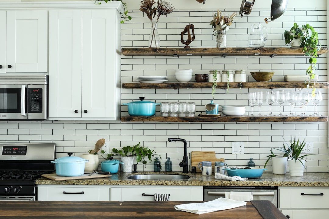 Compact white kitchen with open wood shelves holding everyday cookware and dishes