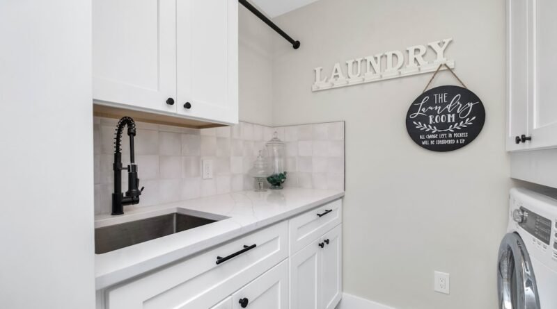 Small laundry room with front-loading washer and dryer, utility sink and built-in storage