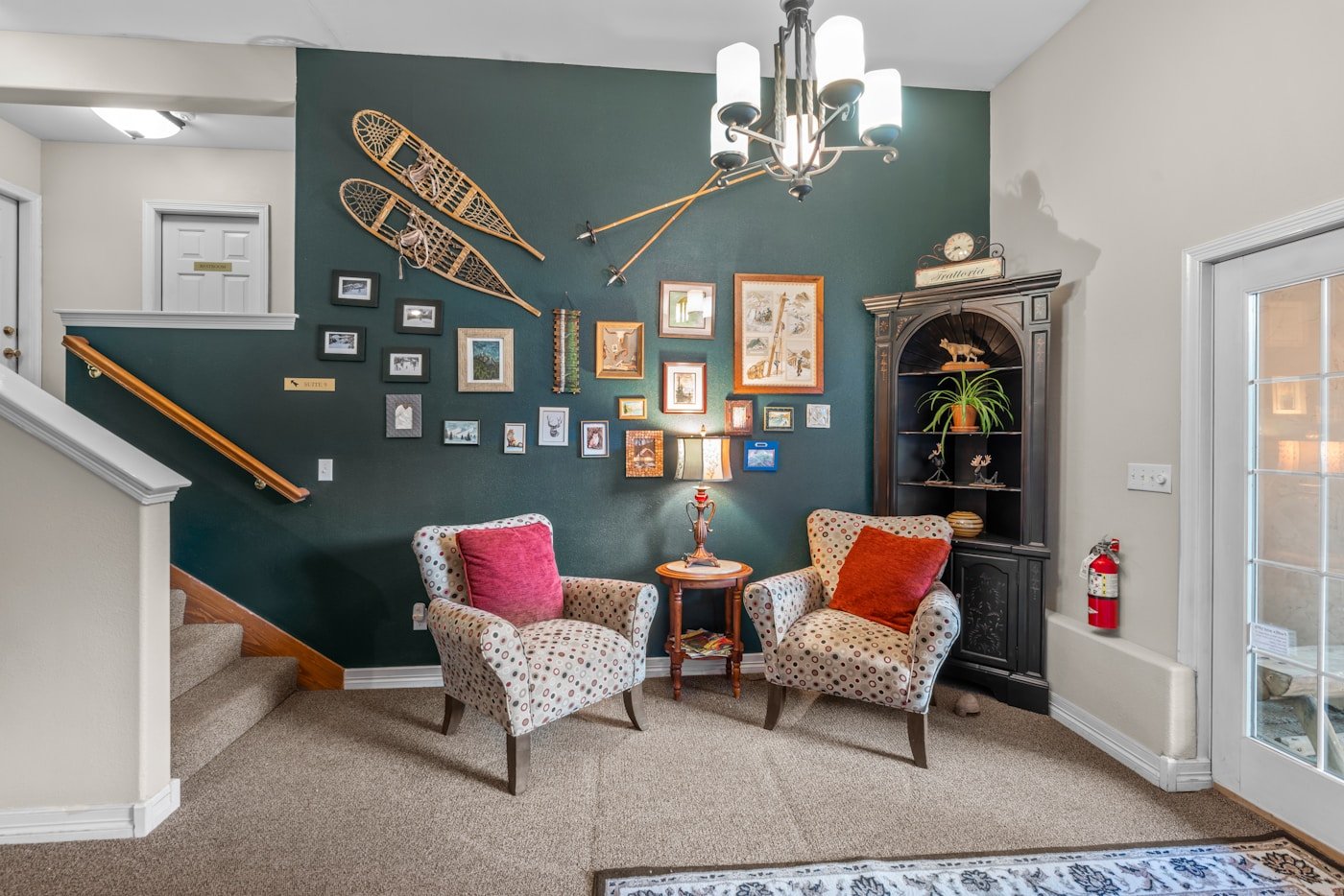 Vintage-inspired sitting room with a mixed gallery wall, patterned chairs and dark painted walls
