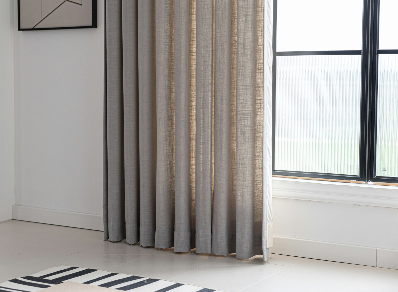 Modern room with warm earth-tone curtains adding softness and privacy to a large window
