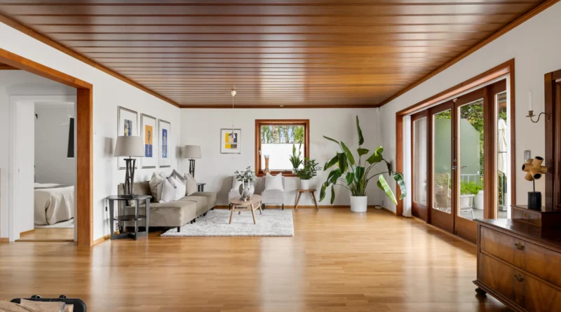 Bright living room with a warm wood-plank ceiling, neutral seating and large windows